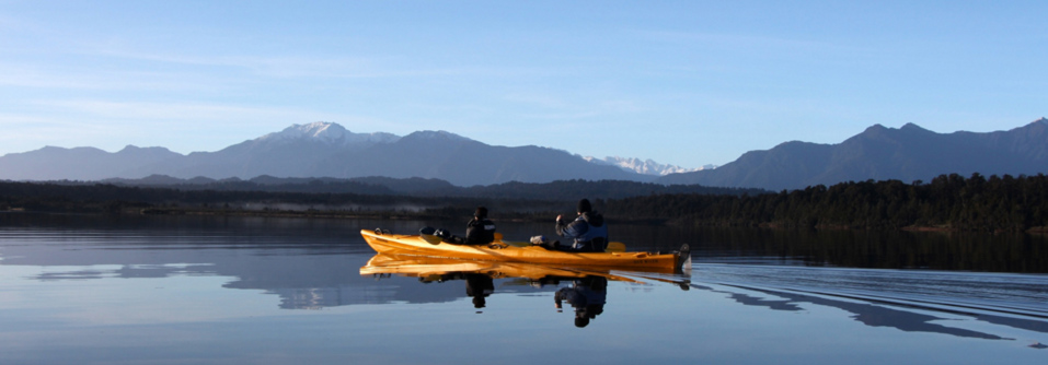 Kayakers on Okarito lagoon, where Okarito Sandfly Repellent was born